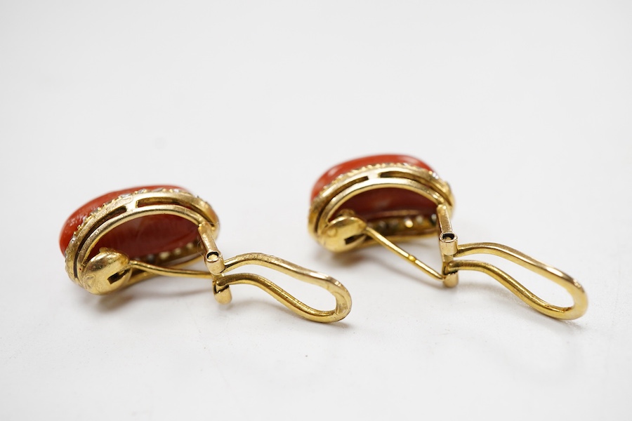 A pair of recent yellow metal, coral and diamond ear ring/clips, each oval coral bordered with diamonds, 15mm.